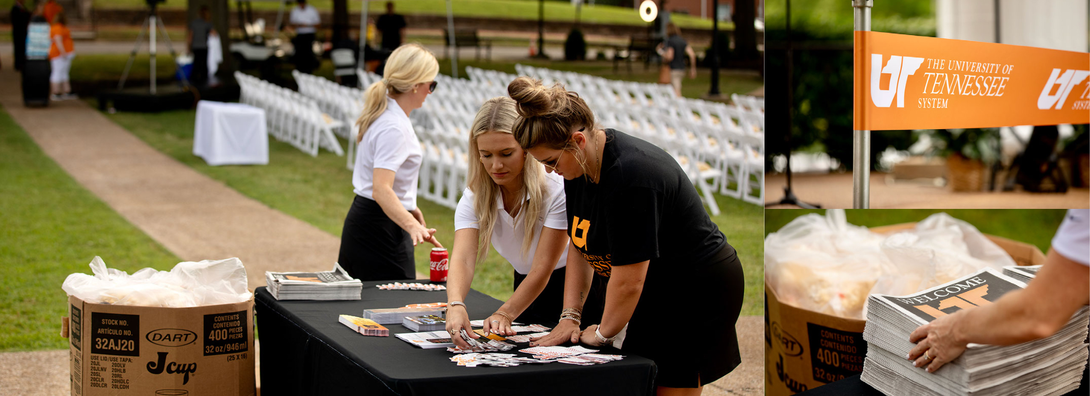 Three communications team members setting up a table display outside